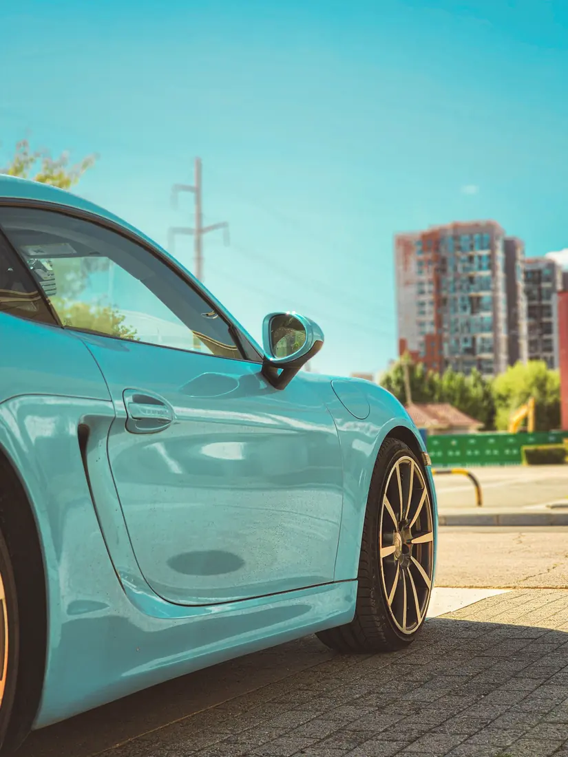 Pulido y encerado de autos: Porsche 911 verde salvia en showroom con acabado satinado