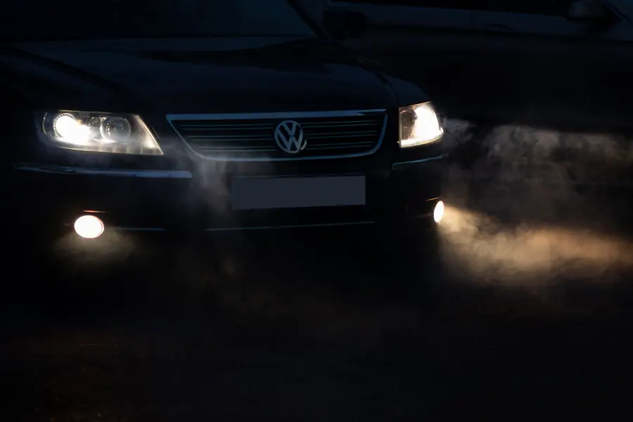 Faros de coche opacos: Faro delantero de un auto azul bajo la lluvia