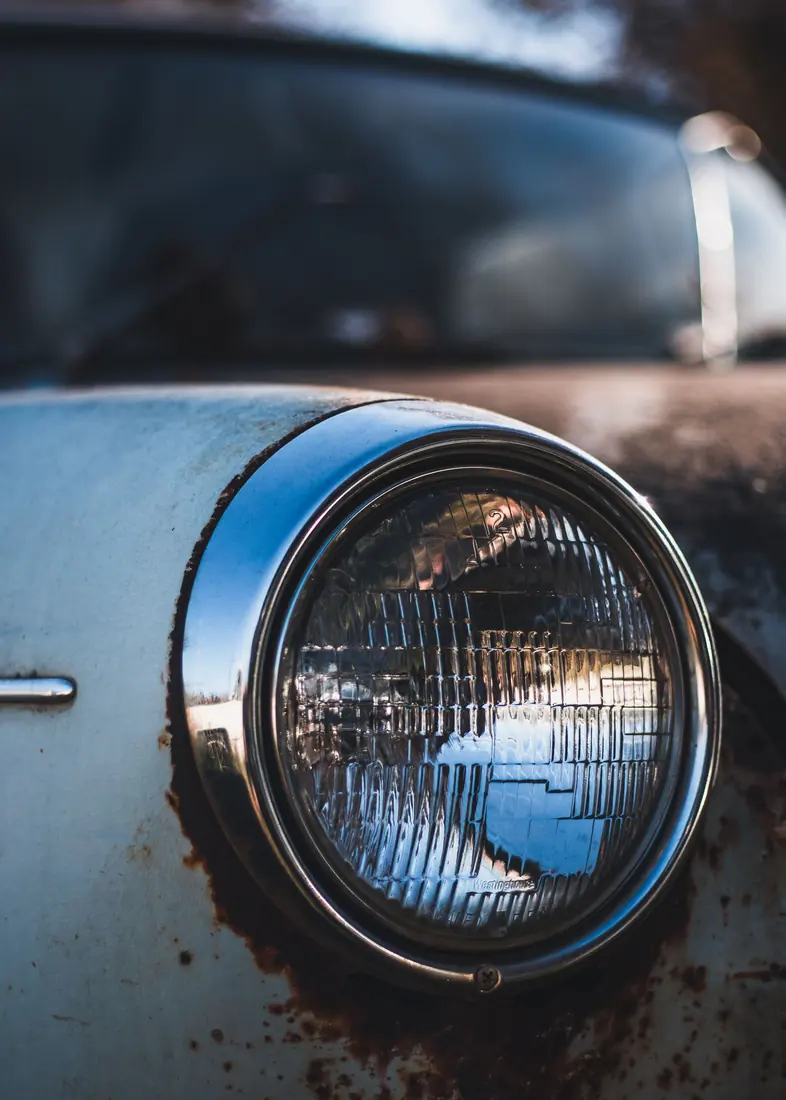 Restauracion de faros: Faro opaco en un auto rojo antes de la restauración