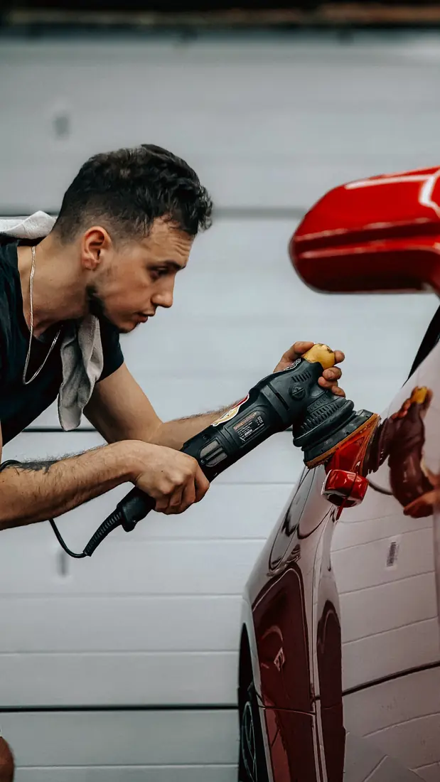 Pulir auto a mano: Superficie de pintura roja con reflejos profundos